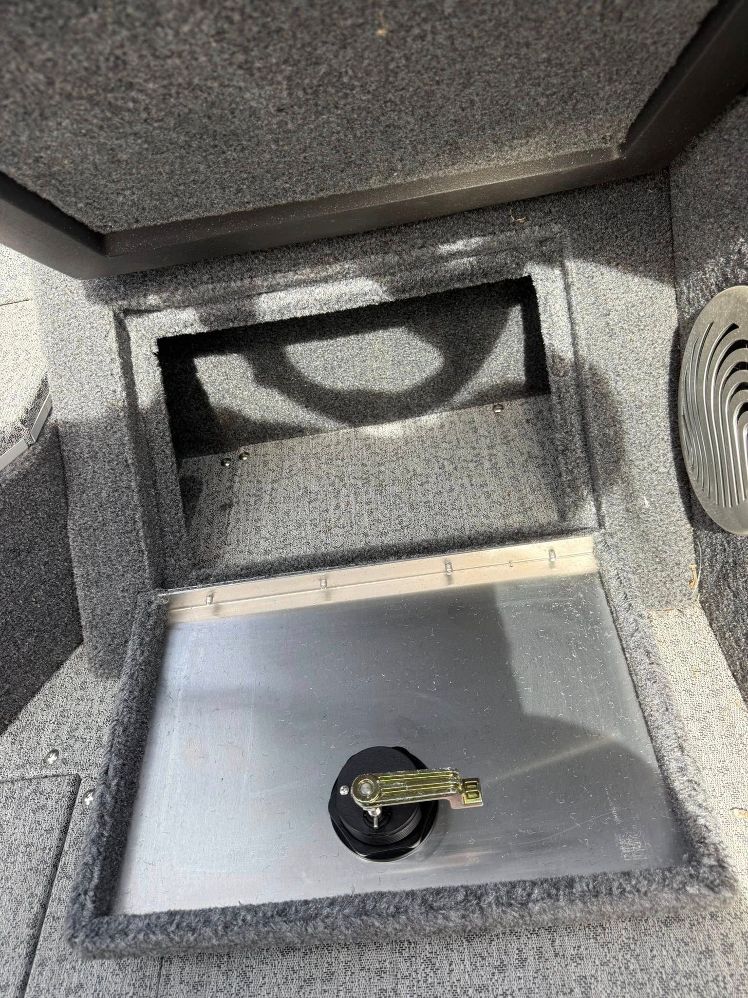 Open safe or cabinet interior with a silver shelf and a small key lying on it.