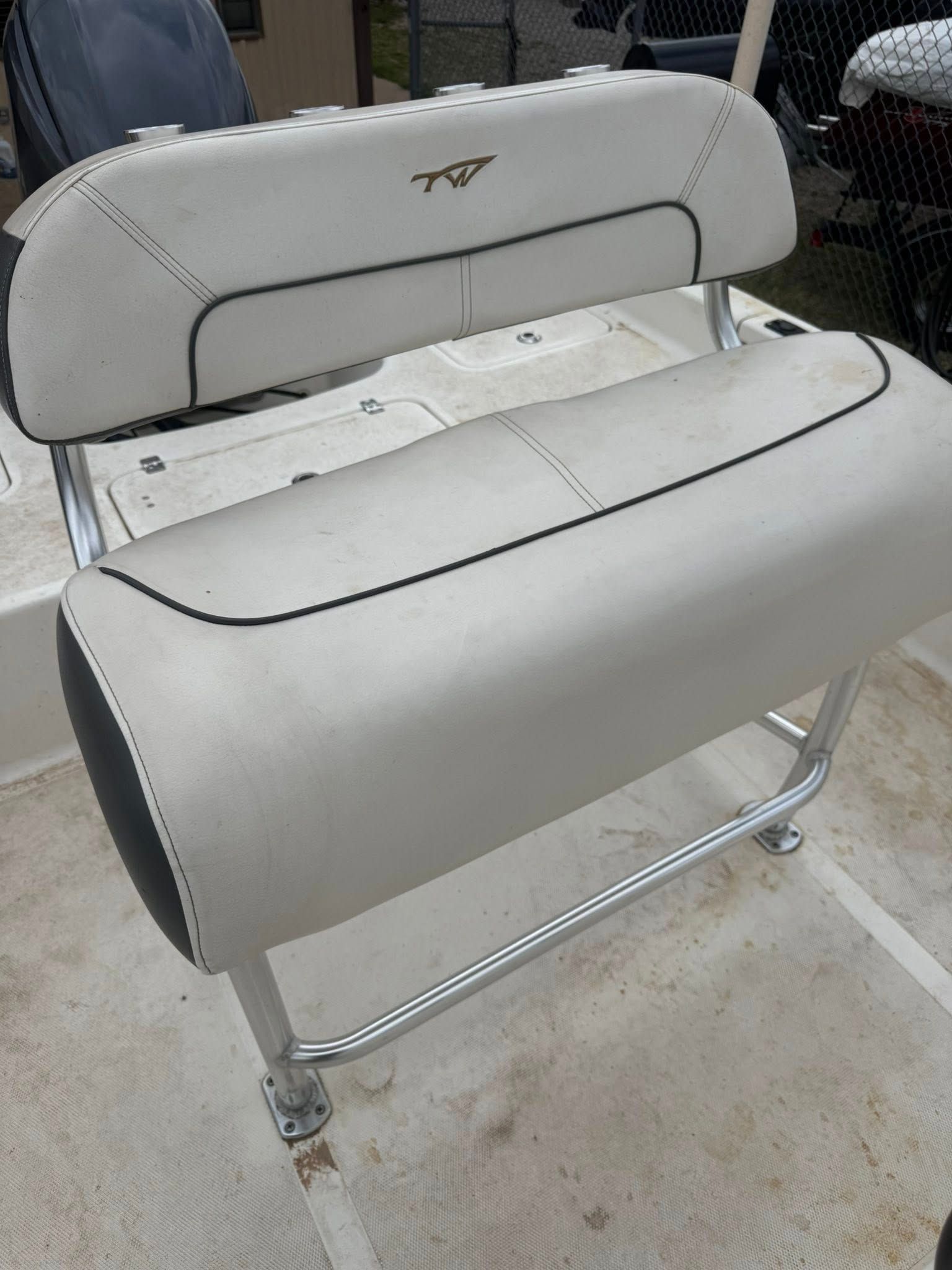 White and gray upholstered bench seat on a metal frame in a workshop or garage