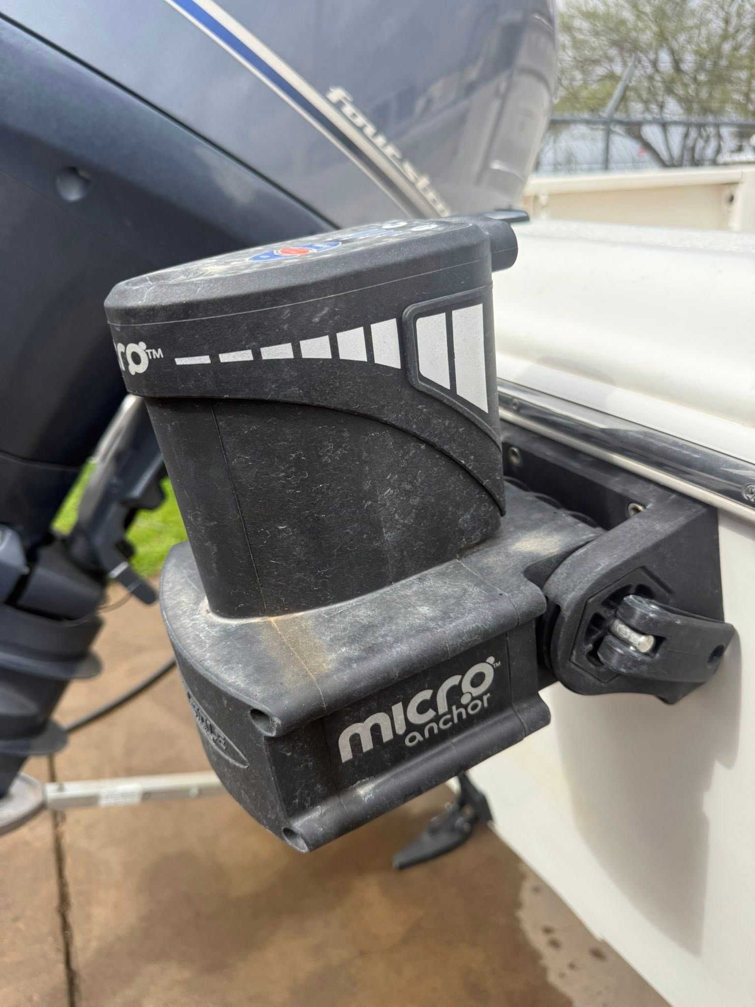 Micro Camp adjustable black clamp mounted on a white boat rail with a blue cover above