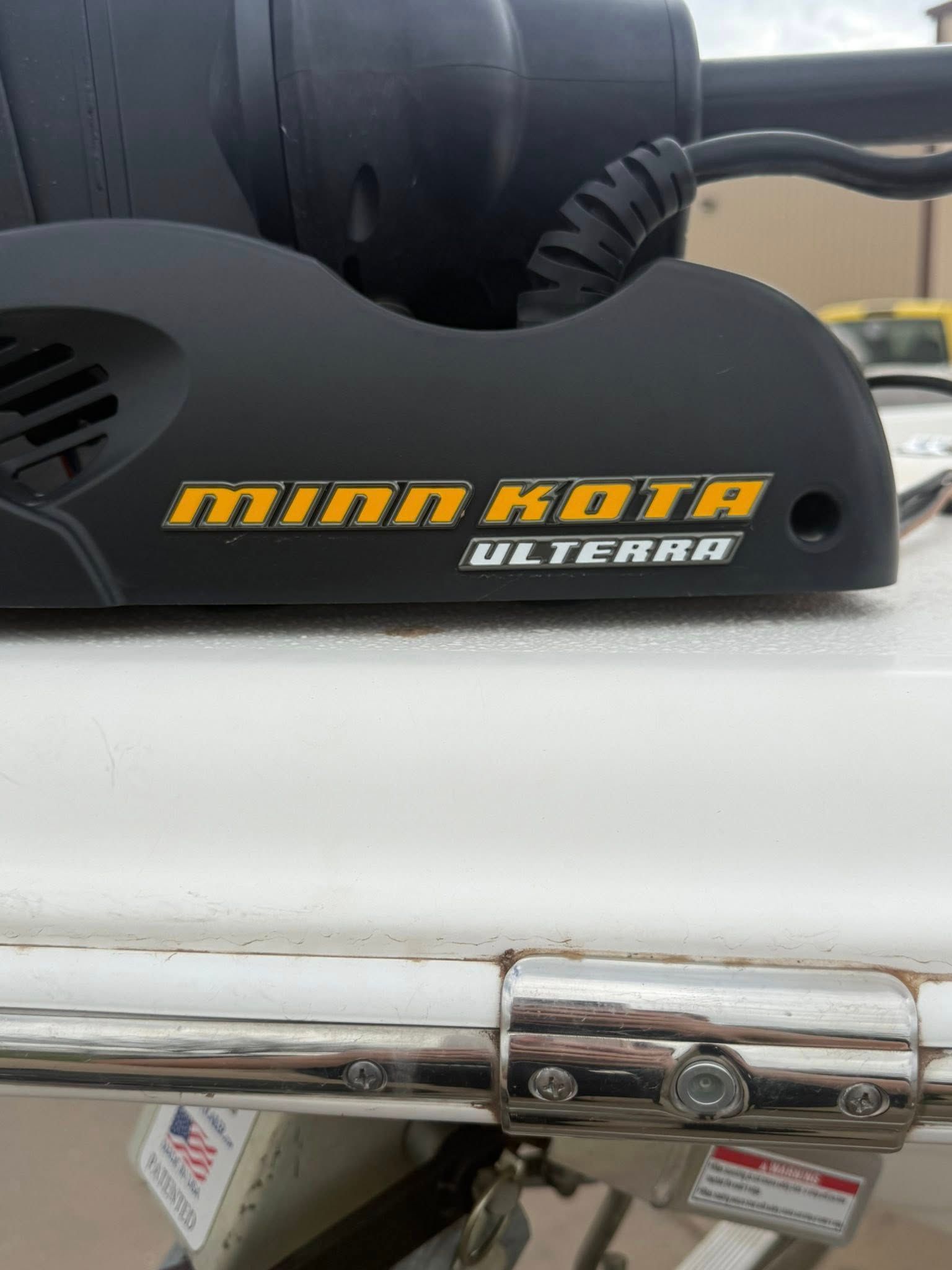Black Minn Kota Ulterra trolling motor mounted on a white boat