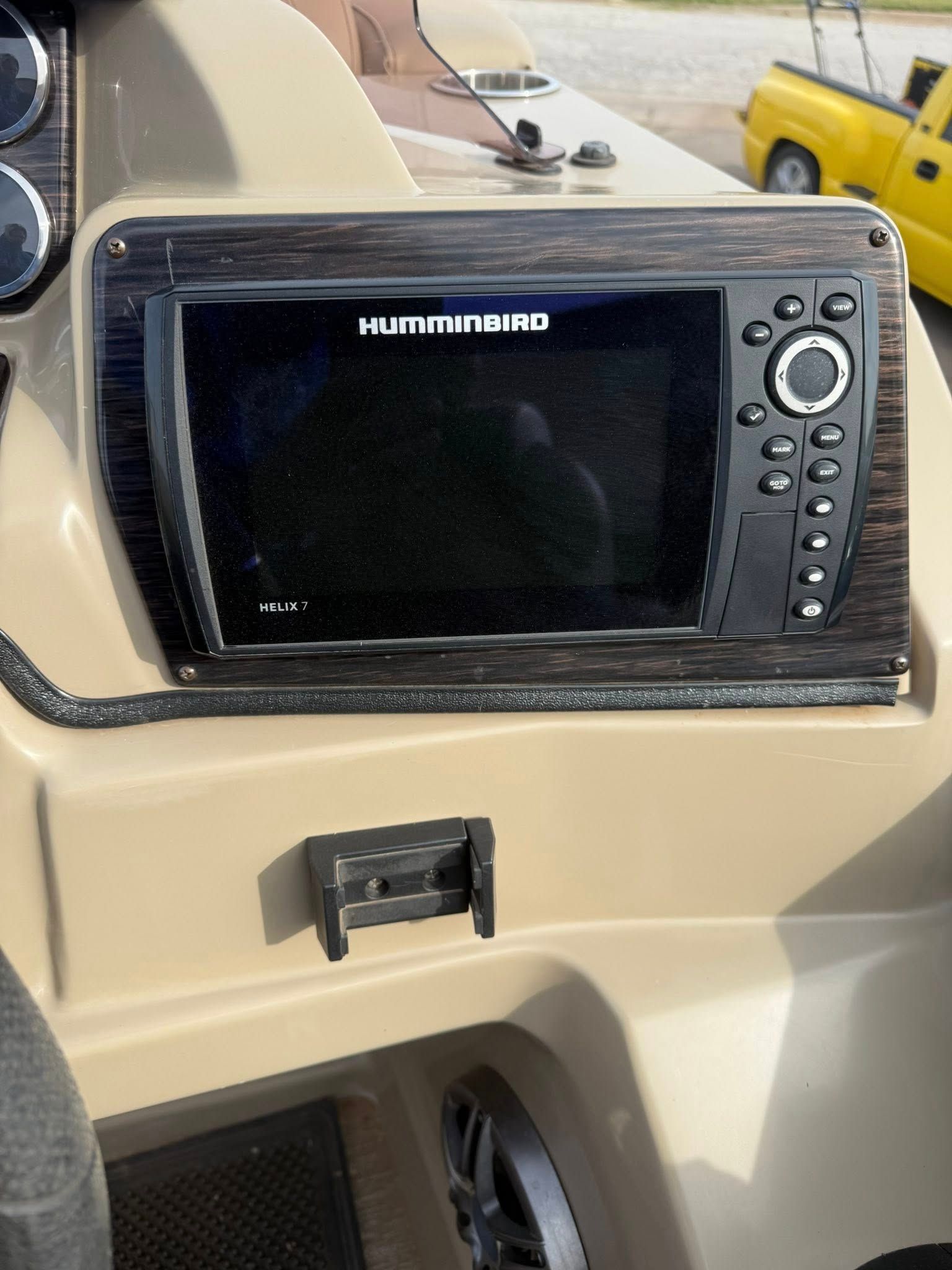 Black Humminbird fish finder mounted in a beige boat console.