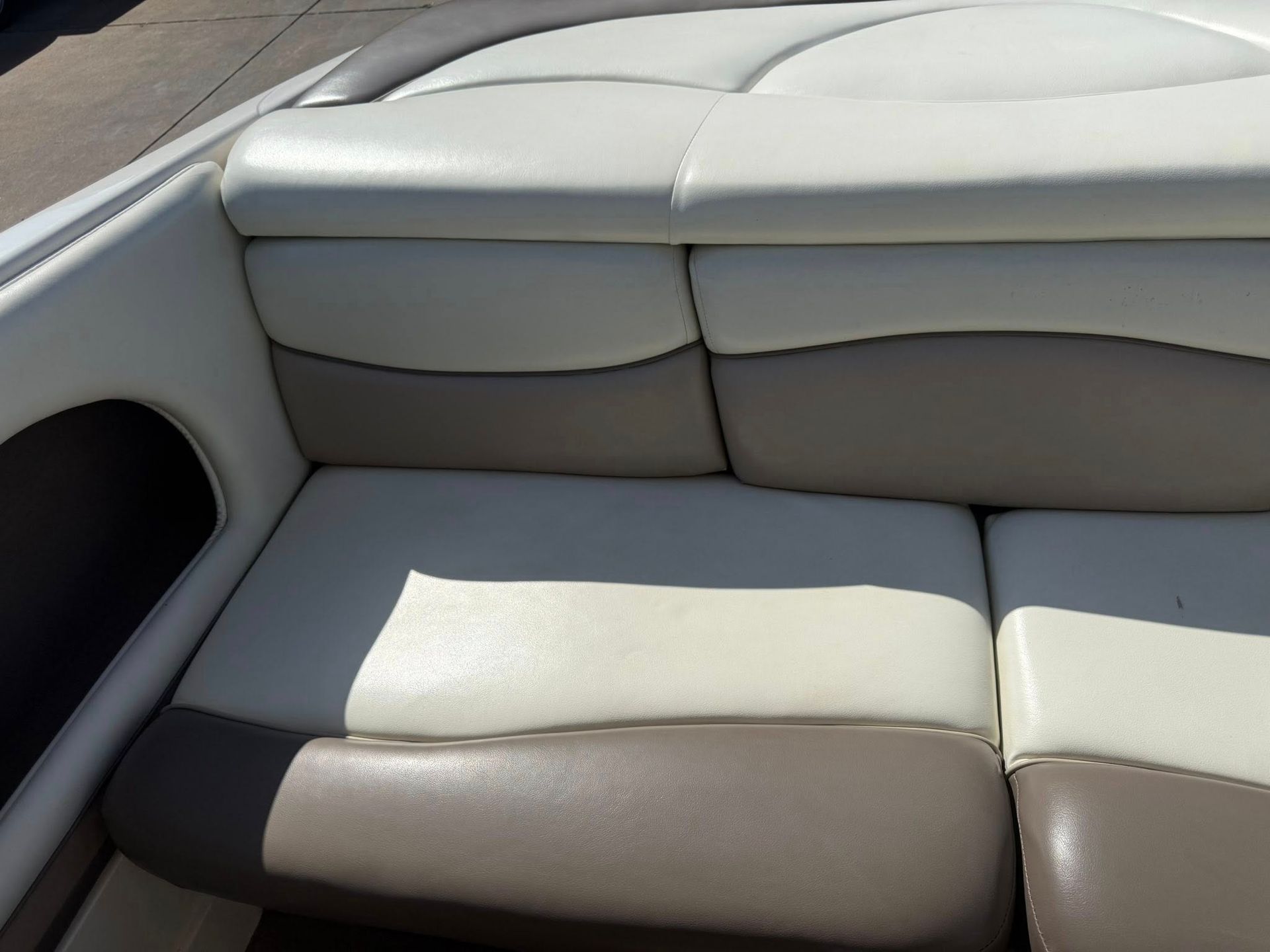 White and gray boat seats with cushioned upholstery in a sunlit interior
