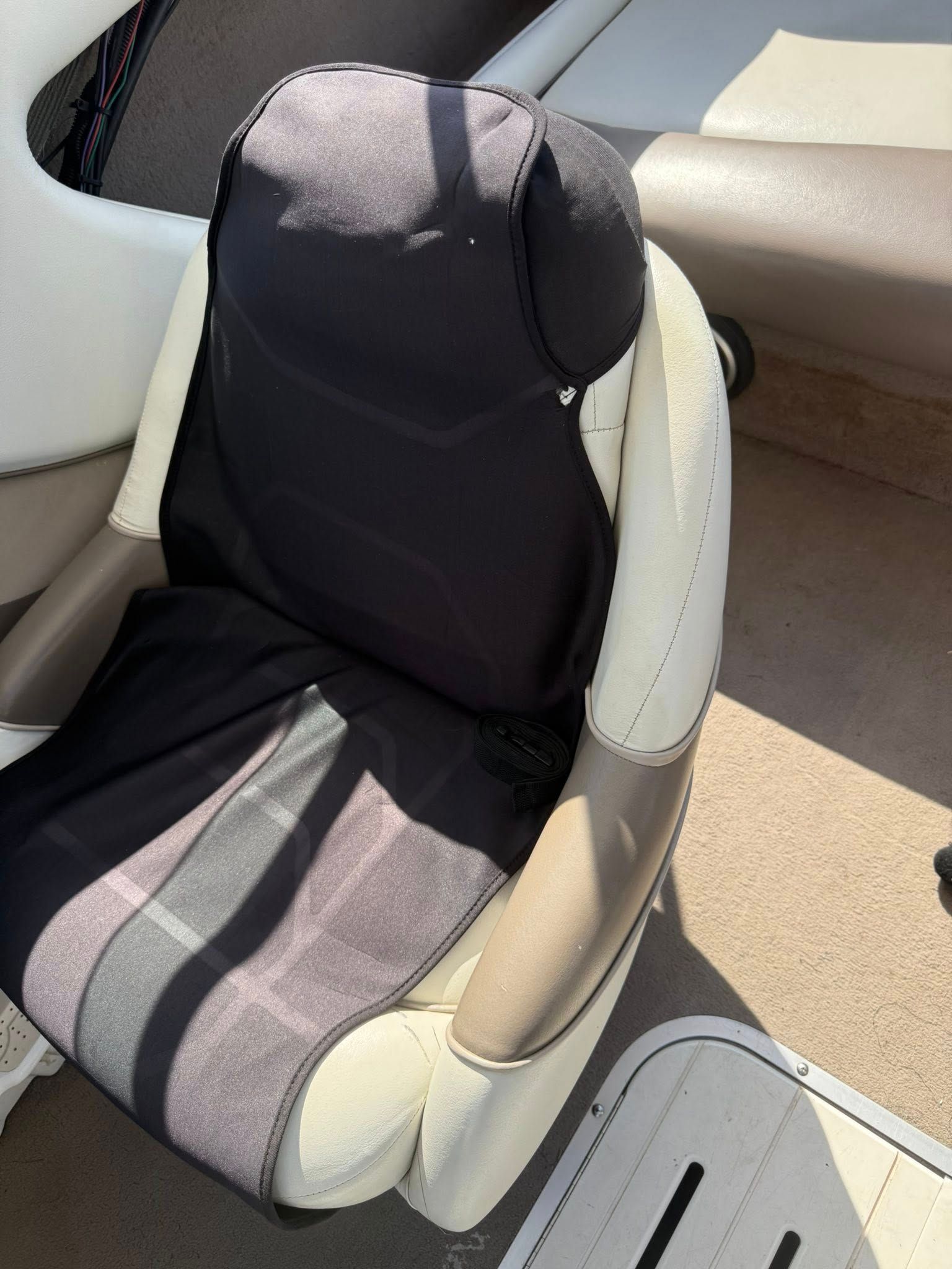 Child car seat with black and beige padding in a vehicle interior.