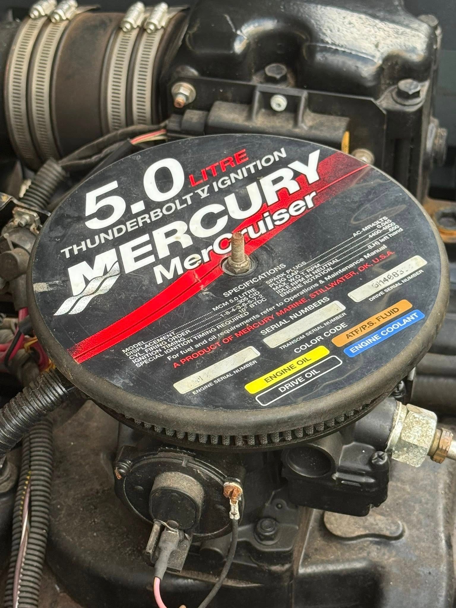 Close-up of a Mercury MerCruiser 5.0 engine cover in a boat engine bay.