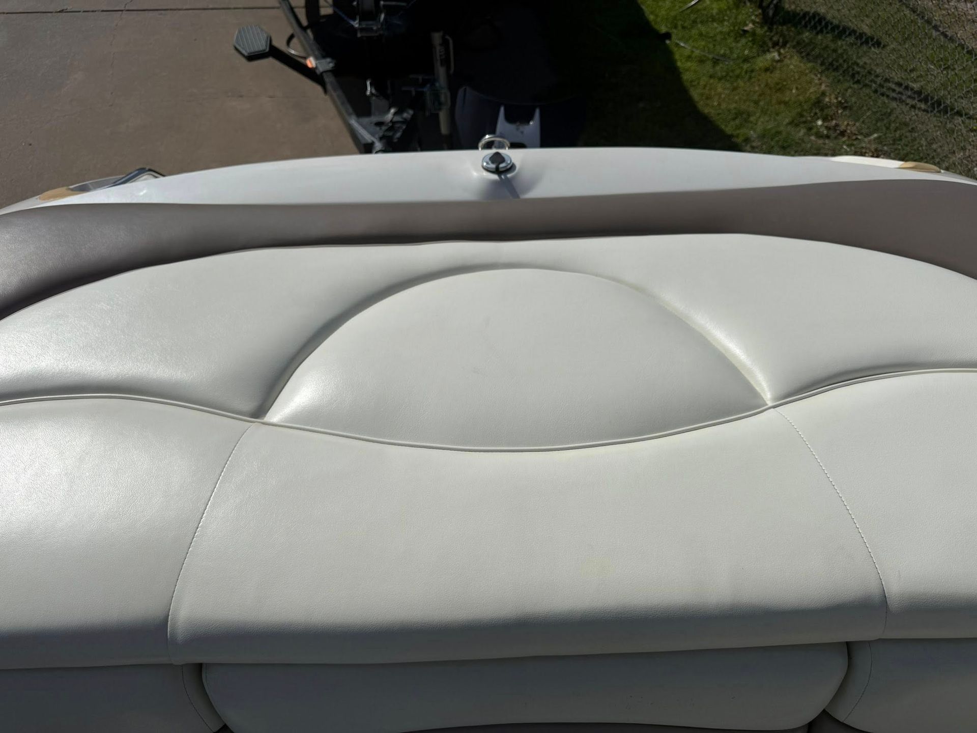 Light gray boat seat with stitched cushions and a small glimpse of the deck behind it