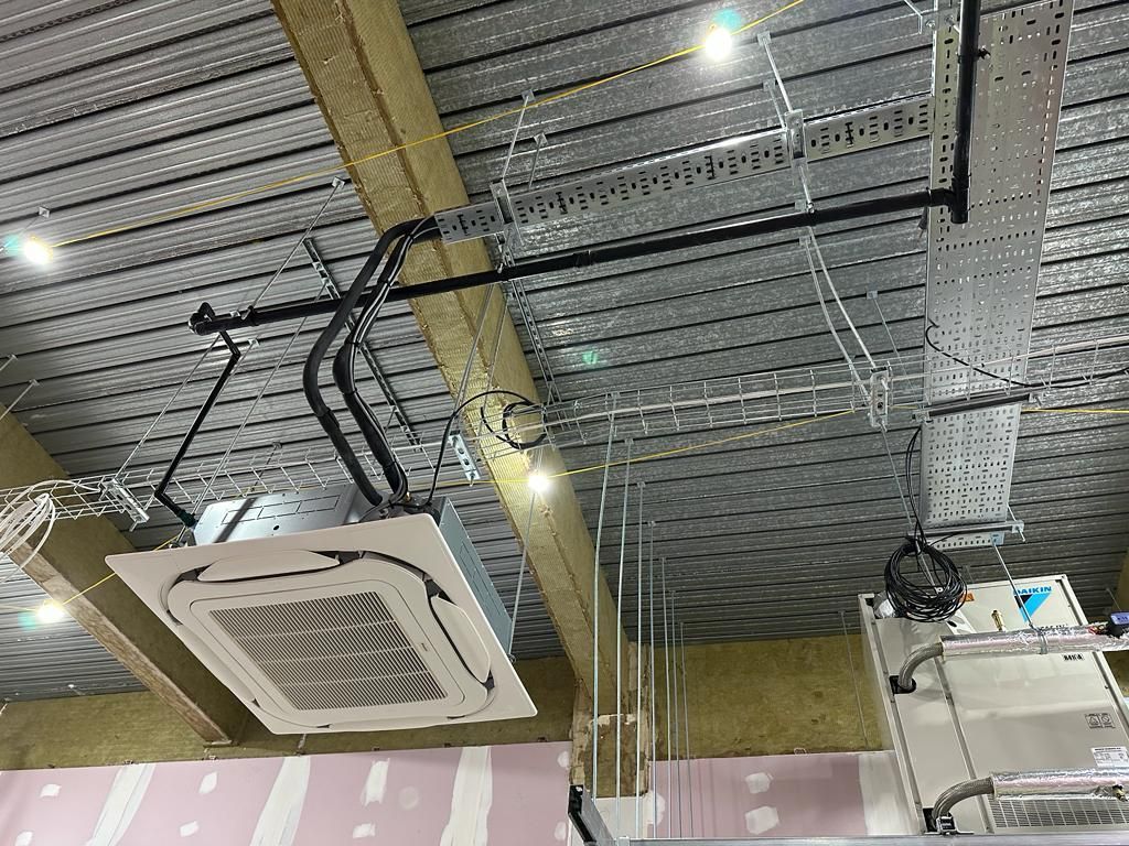 A ceiling with a lot of electrical equipment hanging from it.