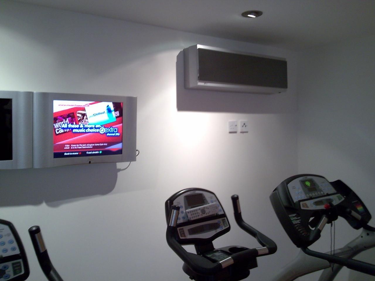 A gym with two exercise bikes and a tv on the wall