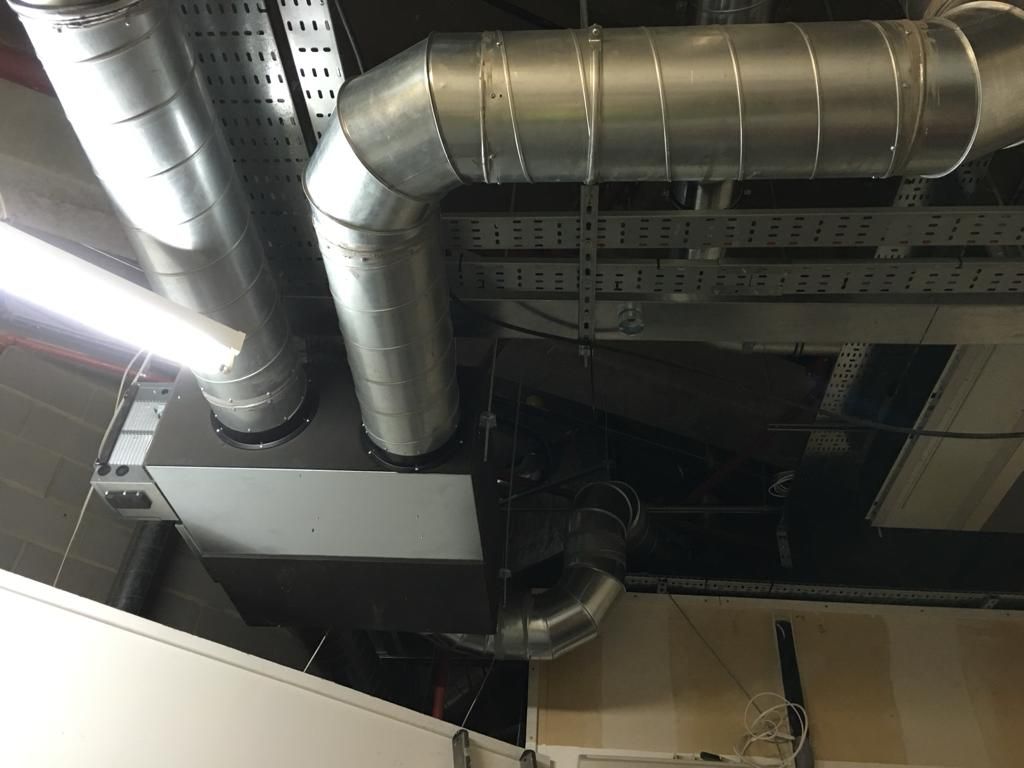 A bunch of metal pipes are hanging from the ceiling of a building.