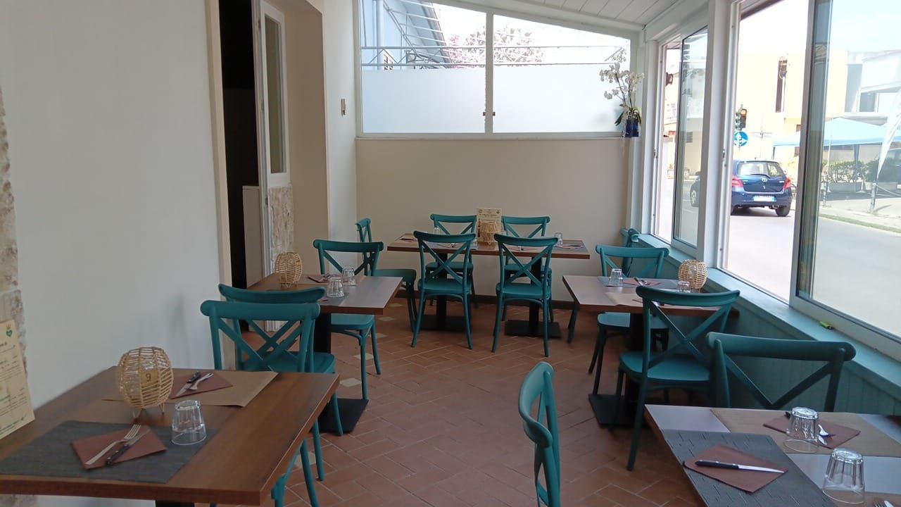 Un ristorante con tavoli e sedie e una grande finestra