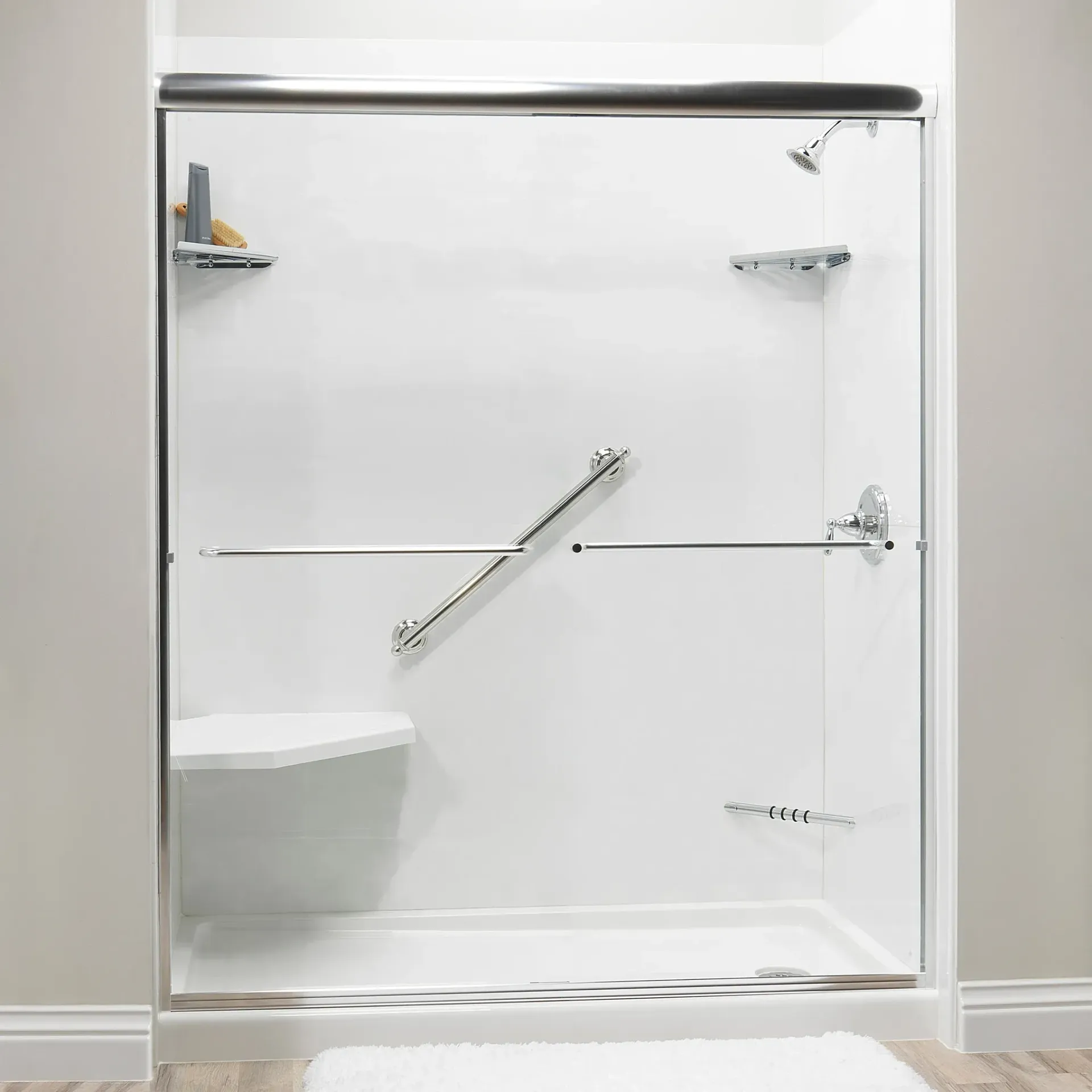 Modern glass shower stall with chrome fixtures, built-in bench, and white tiled walls