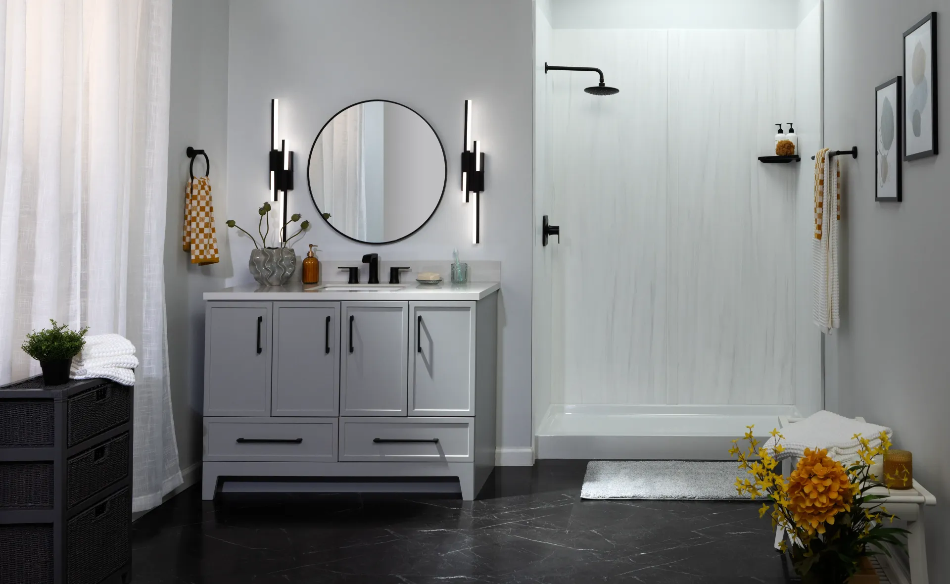 Modern gray bathroom with vanity, round mirror, black fixtures, and white door with flowers