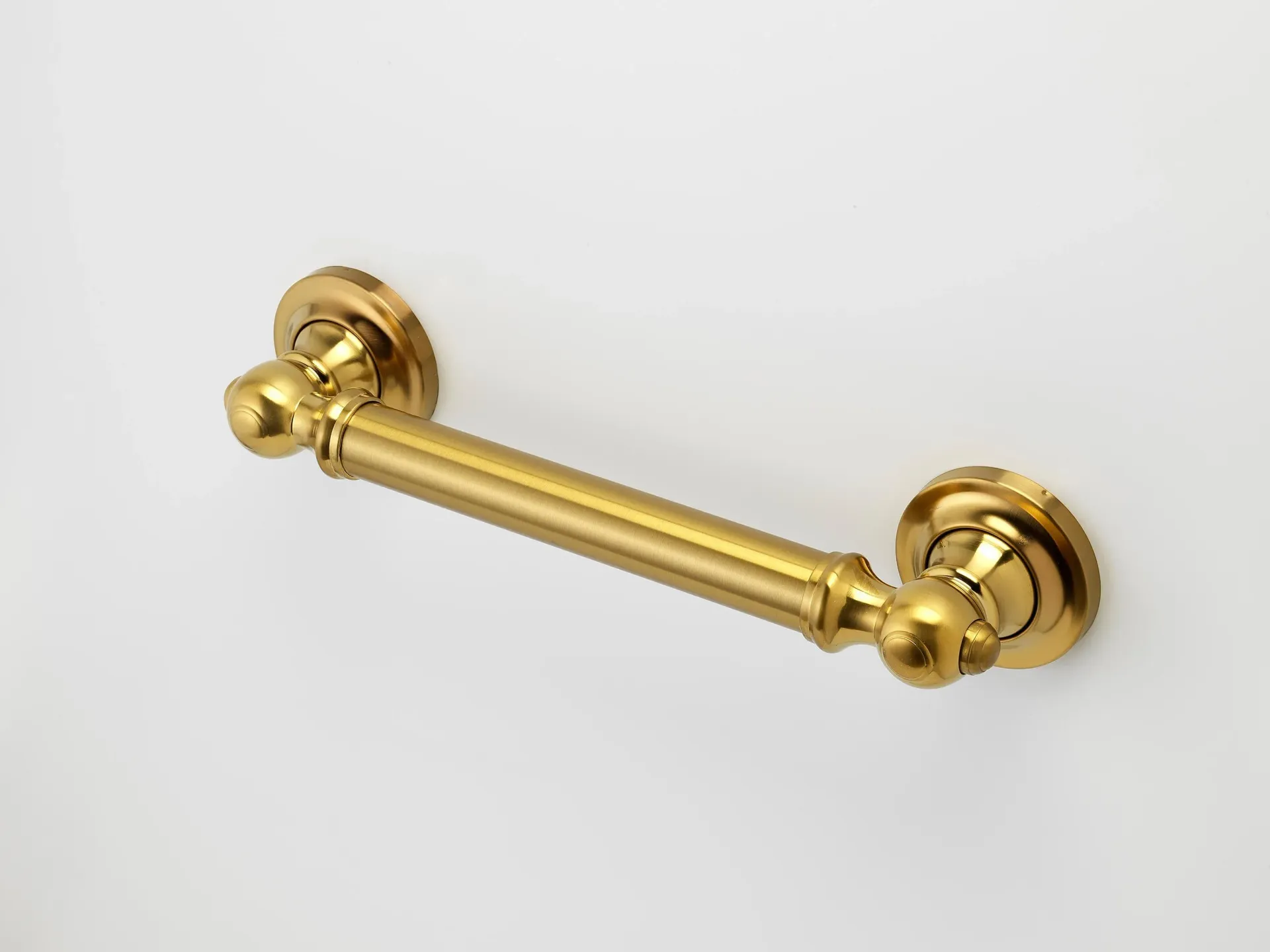 Brass towel bar mounted on a white wall