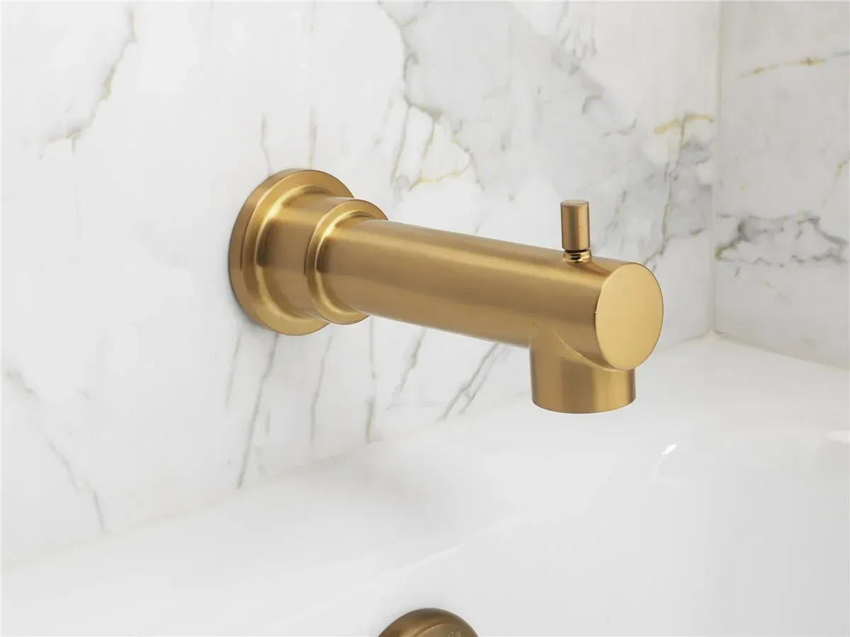 Gold wall-mounted faucet on a white marble bathroom wall, with a round spout and small lever handle.