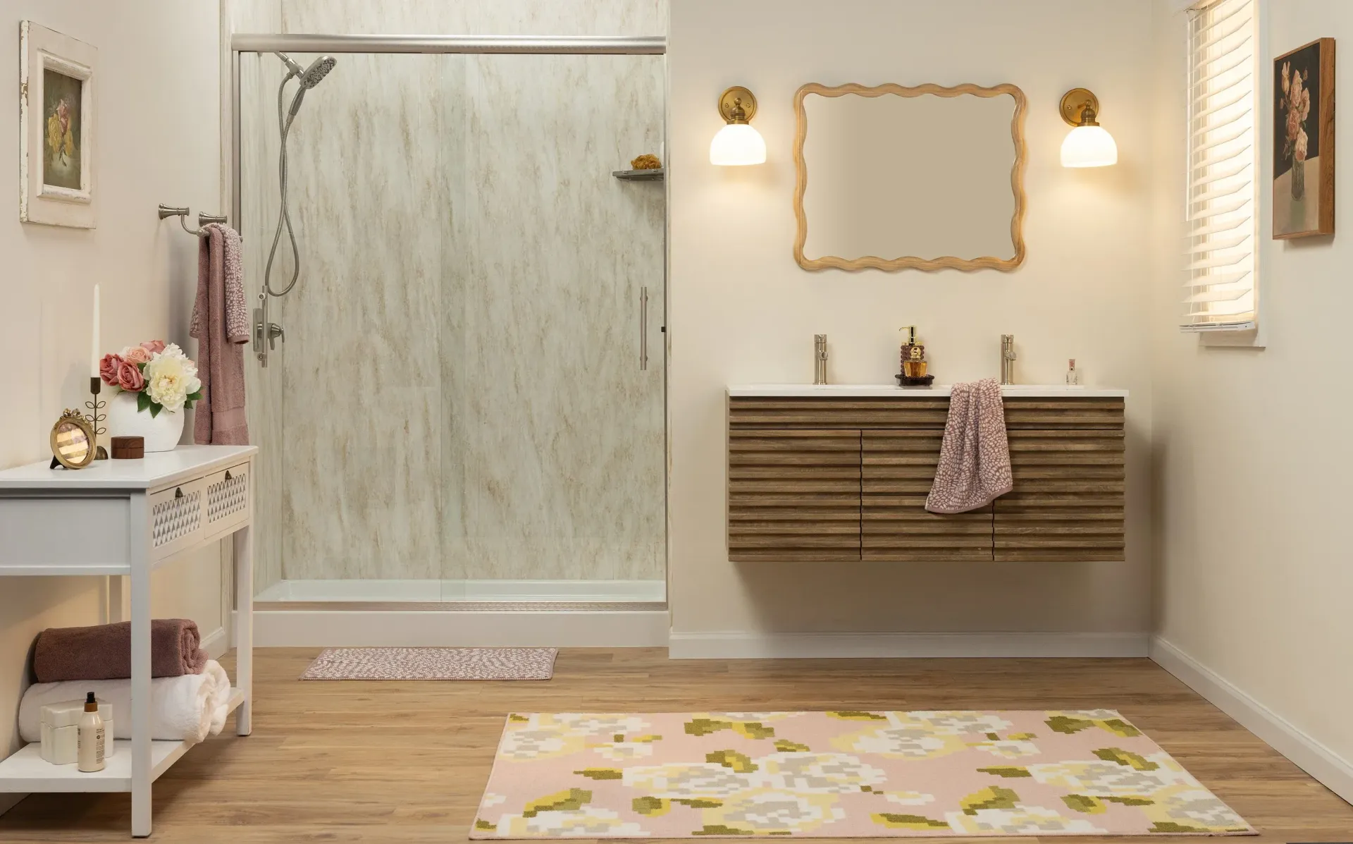 Minimal spa bathroom with glass shower, sink, mirror, wall lights, and floral rug on wood floor.