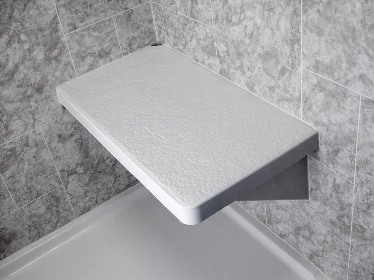 White shower bench mounted in a tiled corner of a bathroom