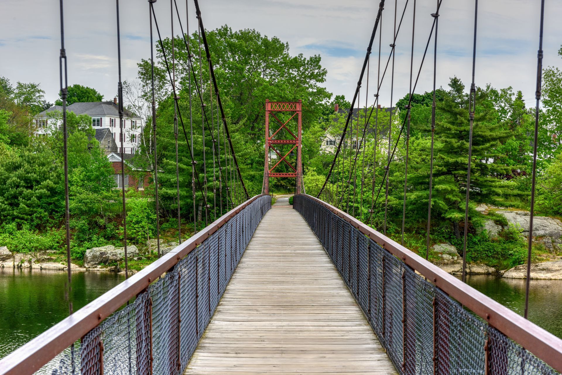 The Androscoggin Swinging Bridge spanning the Androscoggin River between the Topsham Heights neighborhood of Topsham, Maine and neighboring Brunswick.