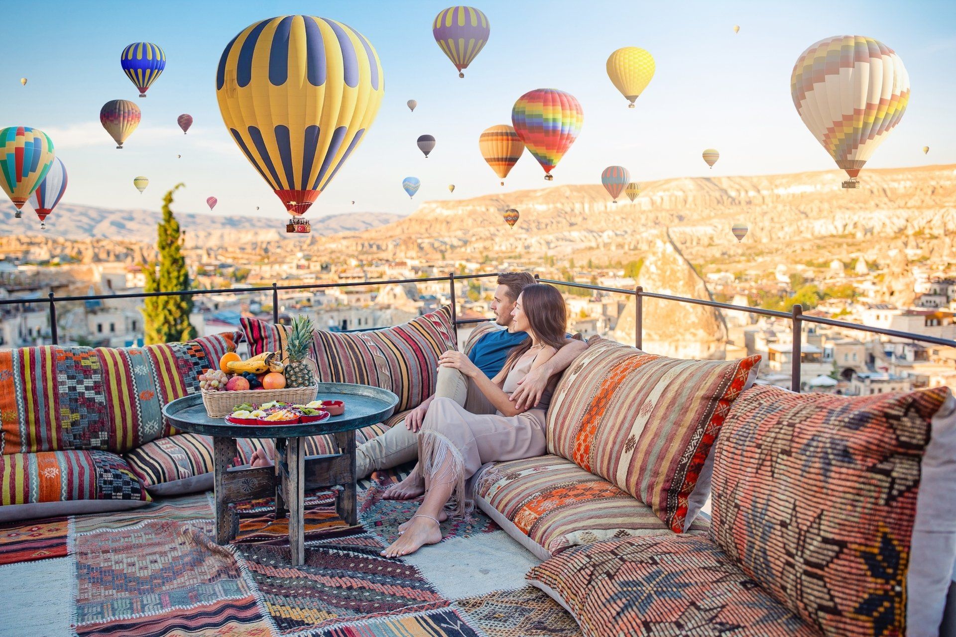 Happy young couple during sunrise watching hot air balloons in Cappadocia, Turkey