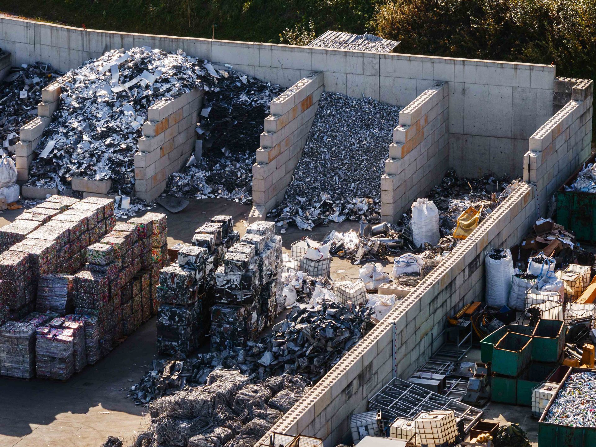 Aerial view of sorted scrap metal piles and compressed bales in a recycling yard. Aerial view of sorted scrap metal piles and compressed bales in a recycling yard.