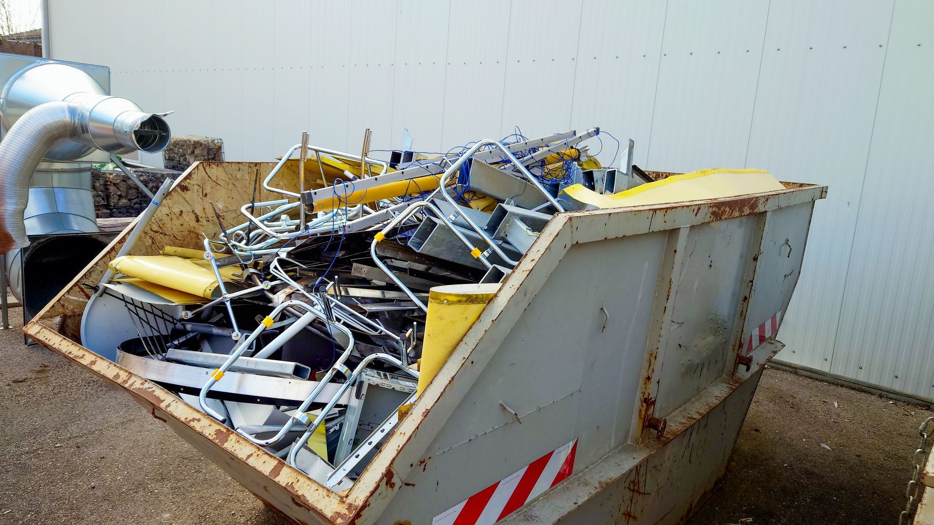 Mixed scrap metal items collected in an industrial bin ready for metal recycling services
