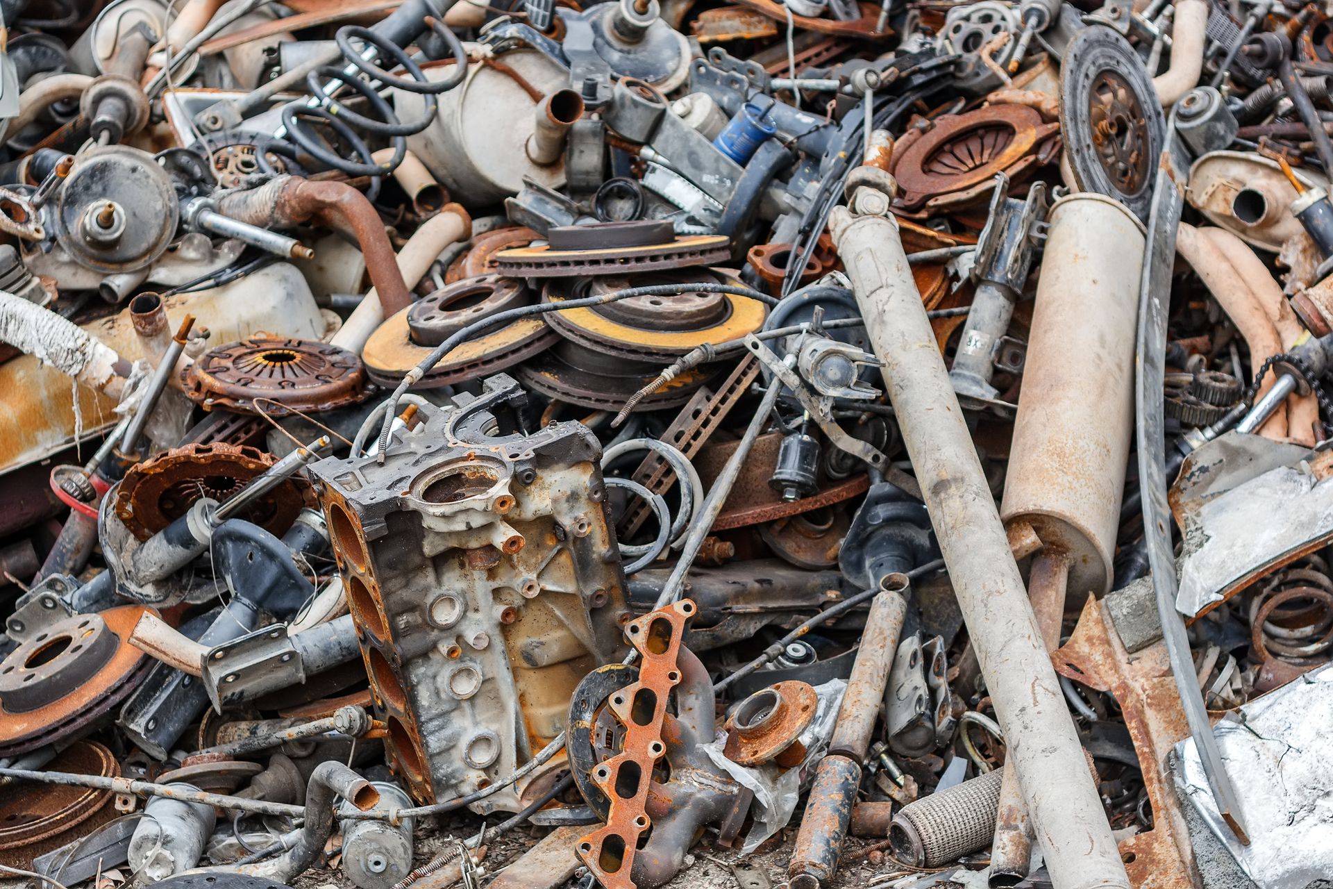 Rusted scrap metal stacked outside, representing reliable scrap metal recycling services.