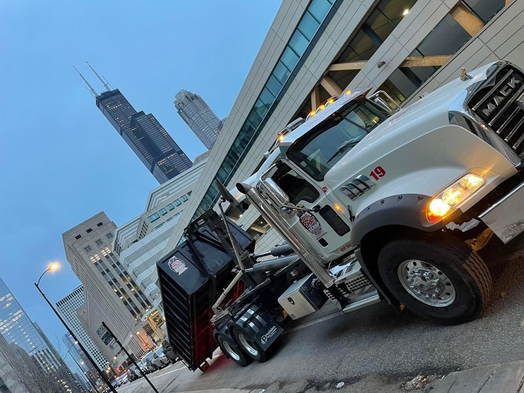 White Mack roll-off truck with a commercial scrap metal recycling container in Chicago. Big Daddy Scrap offers commercial roll-off containers. White Mack roll-off truck with a commercial scrap metal recycling container in Chicago. Big Daddy Scrap offers commercial roll-off containers.