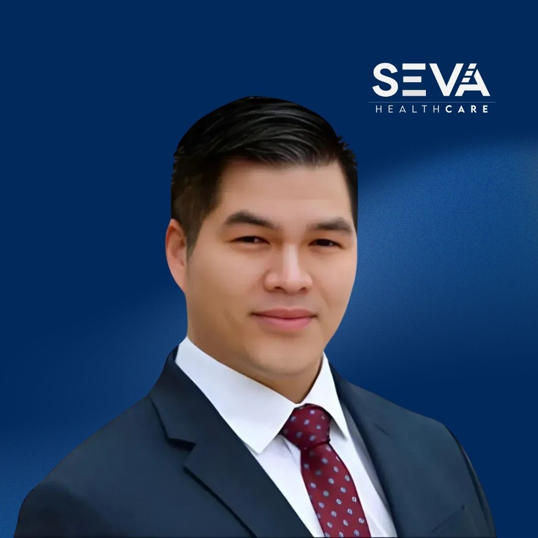 Portrait of a suited man on a blue background with SEVA Healthcare logo