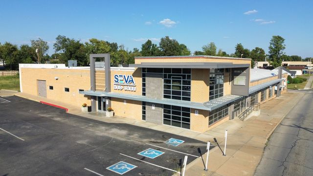 Exterior of a beige school building with black accents and a handicap parking lot