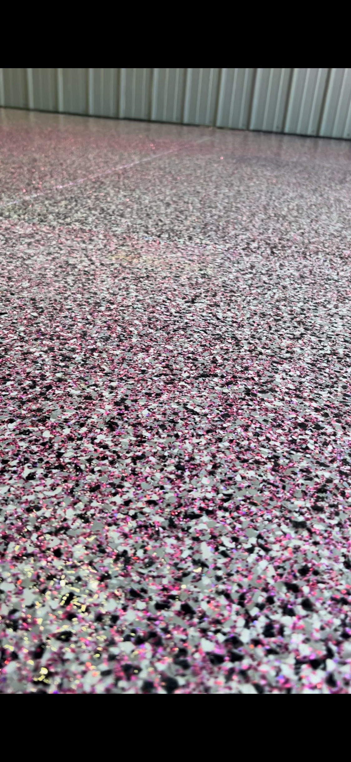 Pink and grey speckled epoxy flooring in a building.