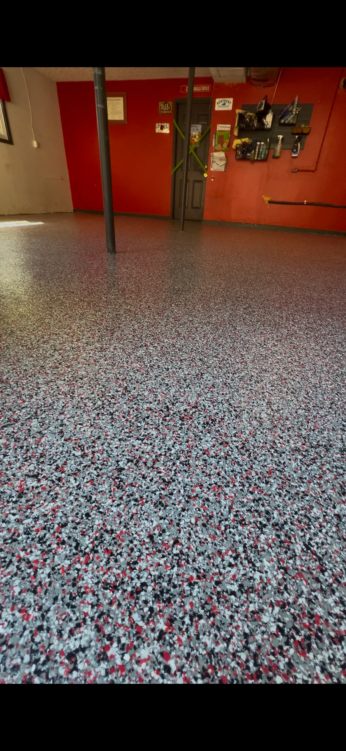A room with a speckled gray and red floor and red walls.