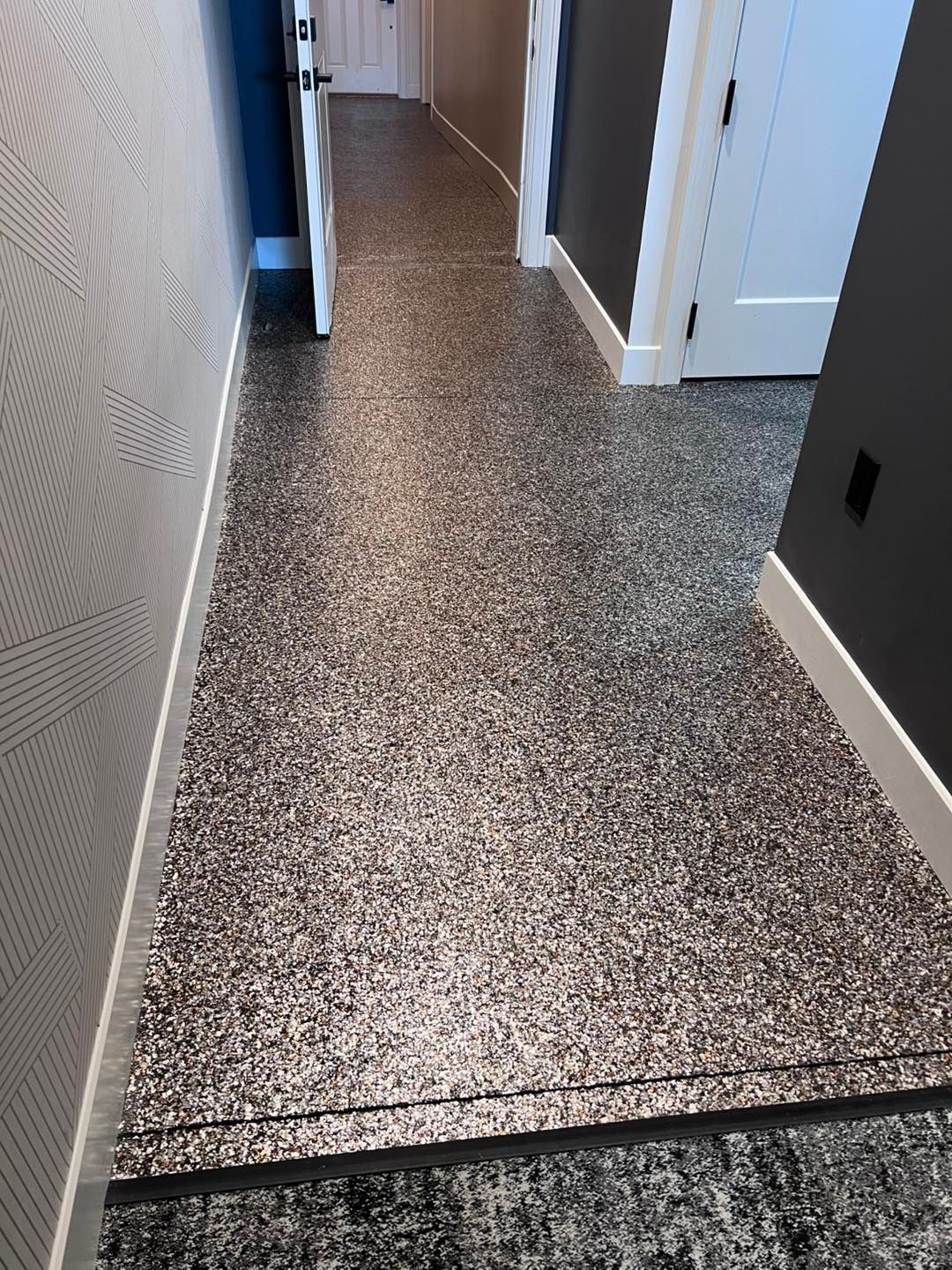 Hallway with speckled floor, white trim, and gray and white walls.
