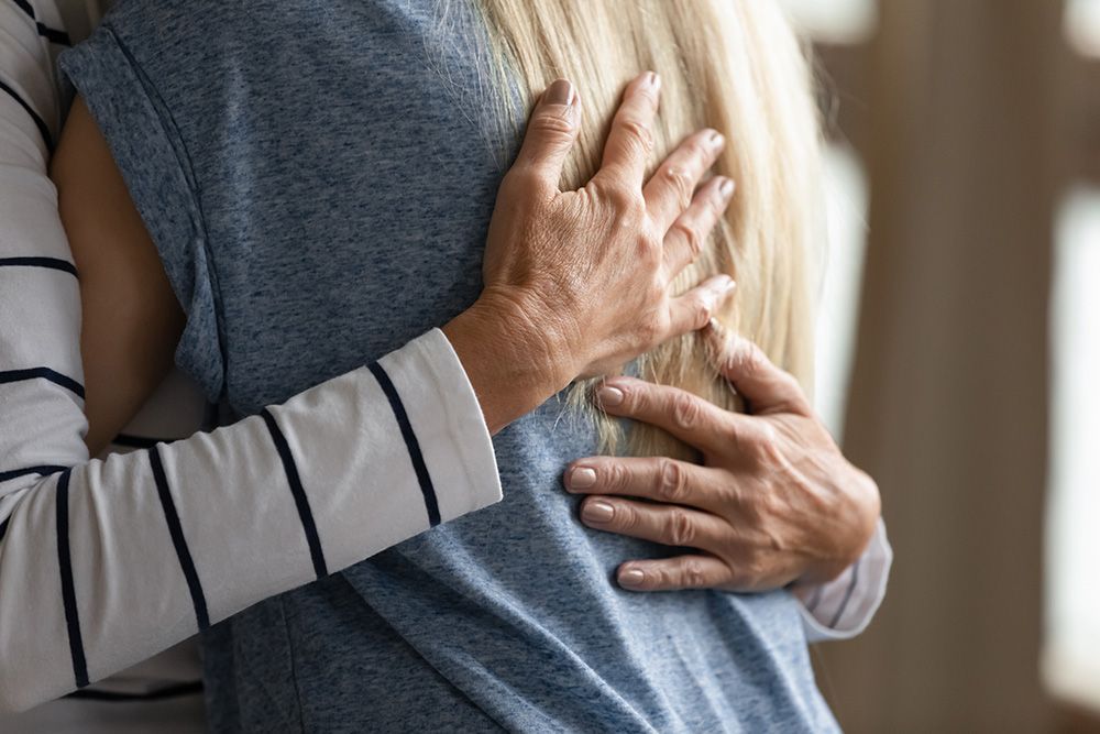 A man is hugging a woman in a blue shirt.