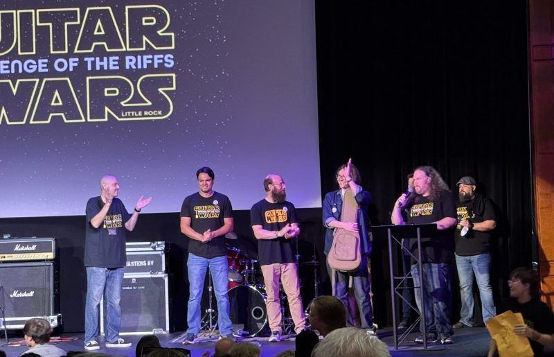 A small group of contestants on stage at the Guitar Wars event.