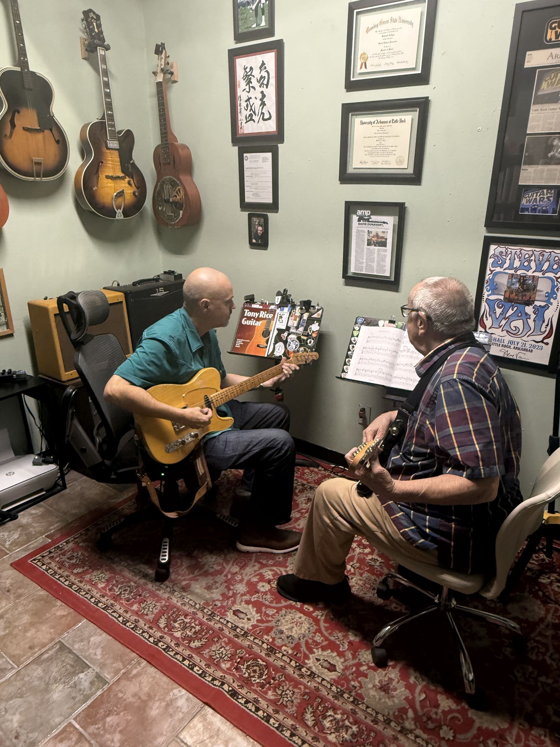 David and an adult student practicing guitar together.