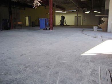A large empty room with a vacuum cleaner on the floor.