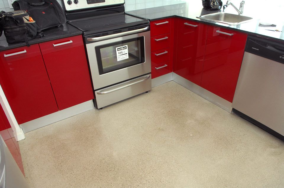 A kitchen with red cabinets and stainless steel appliances
