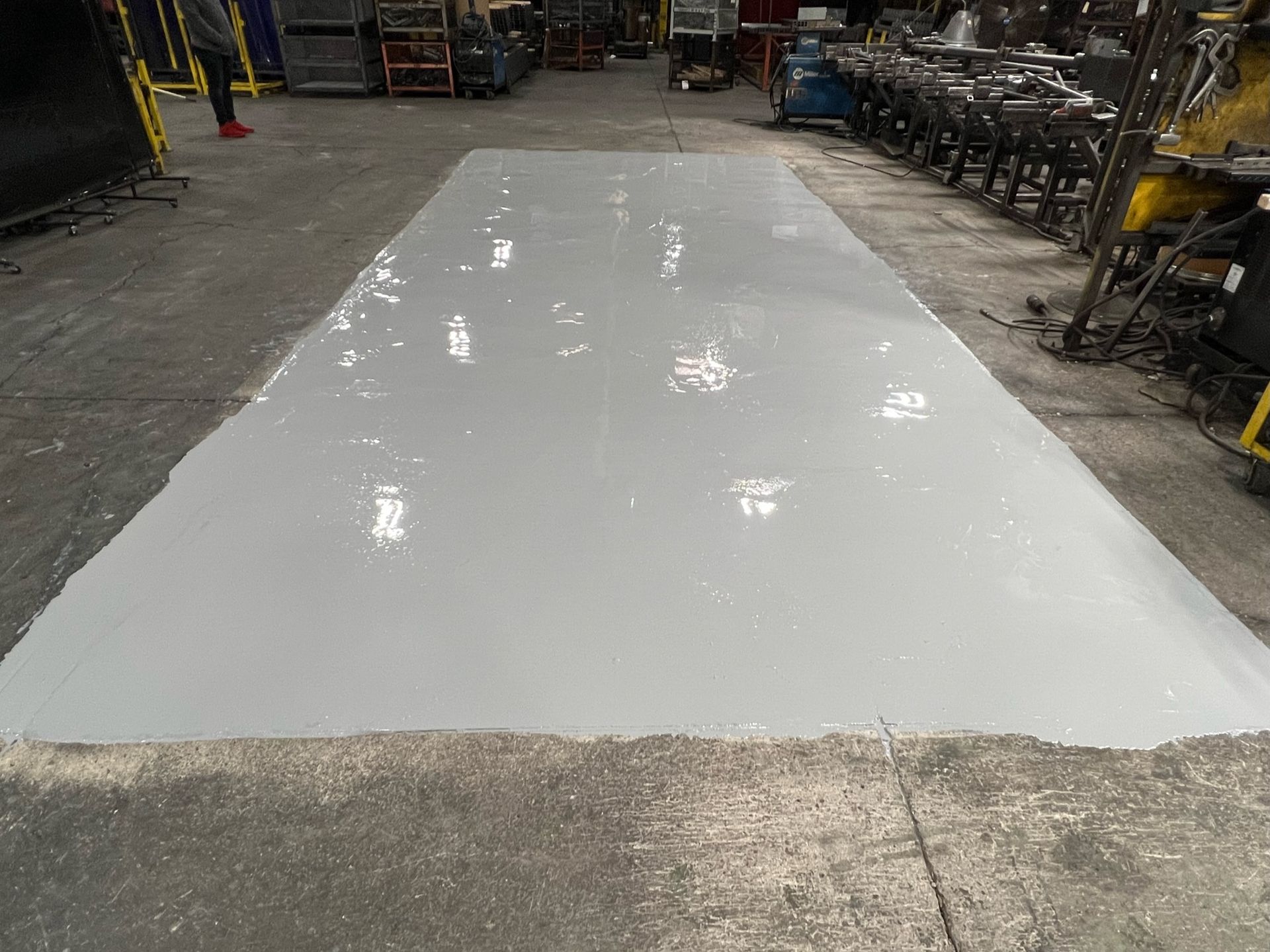 A large white sheet of metal is sitting on top of a concrete floor in a warehouse.