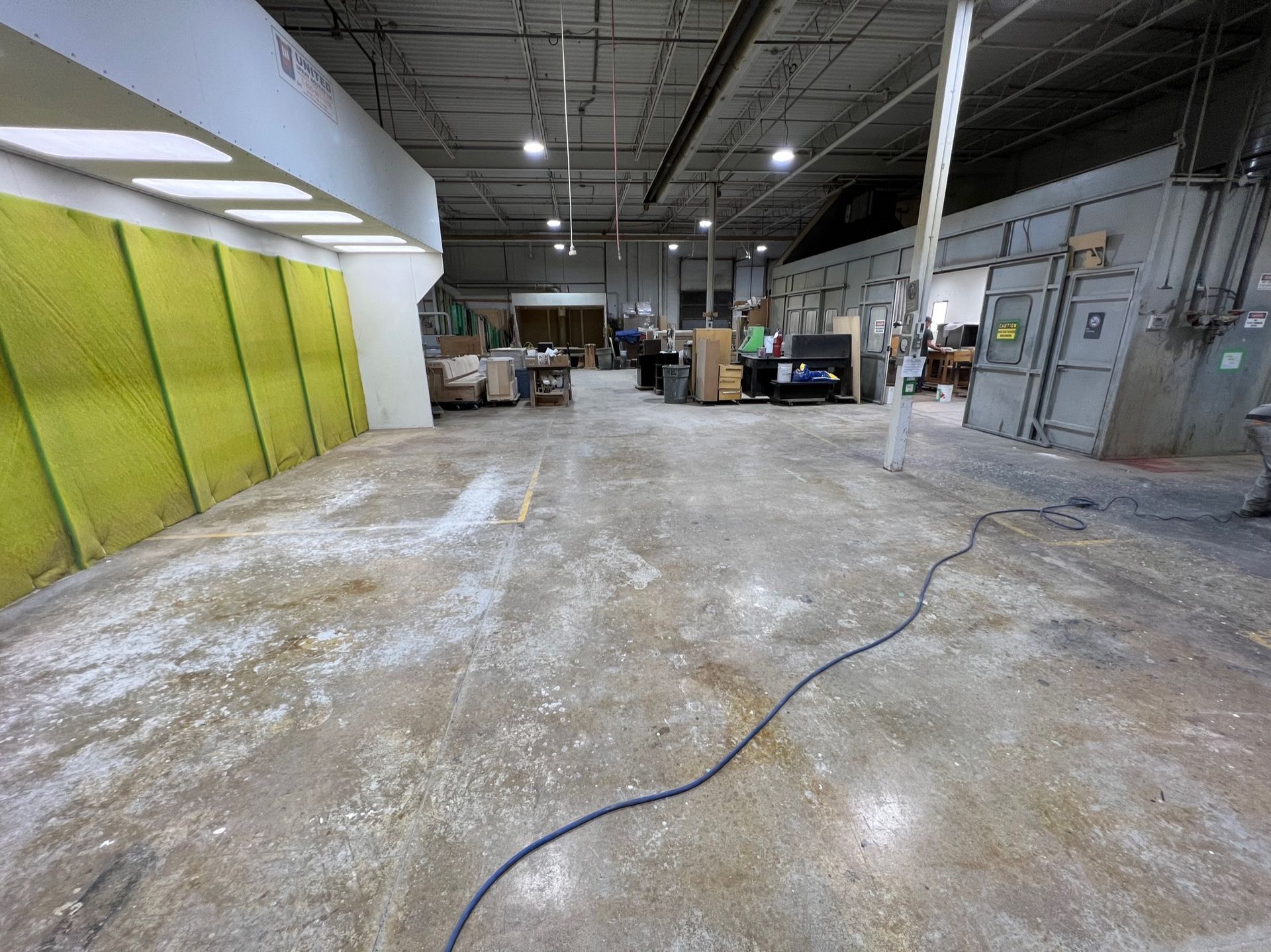 A large empty warehouse with a blue cord hanging from the ceiling.