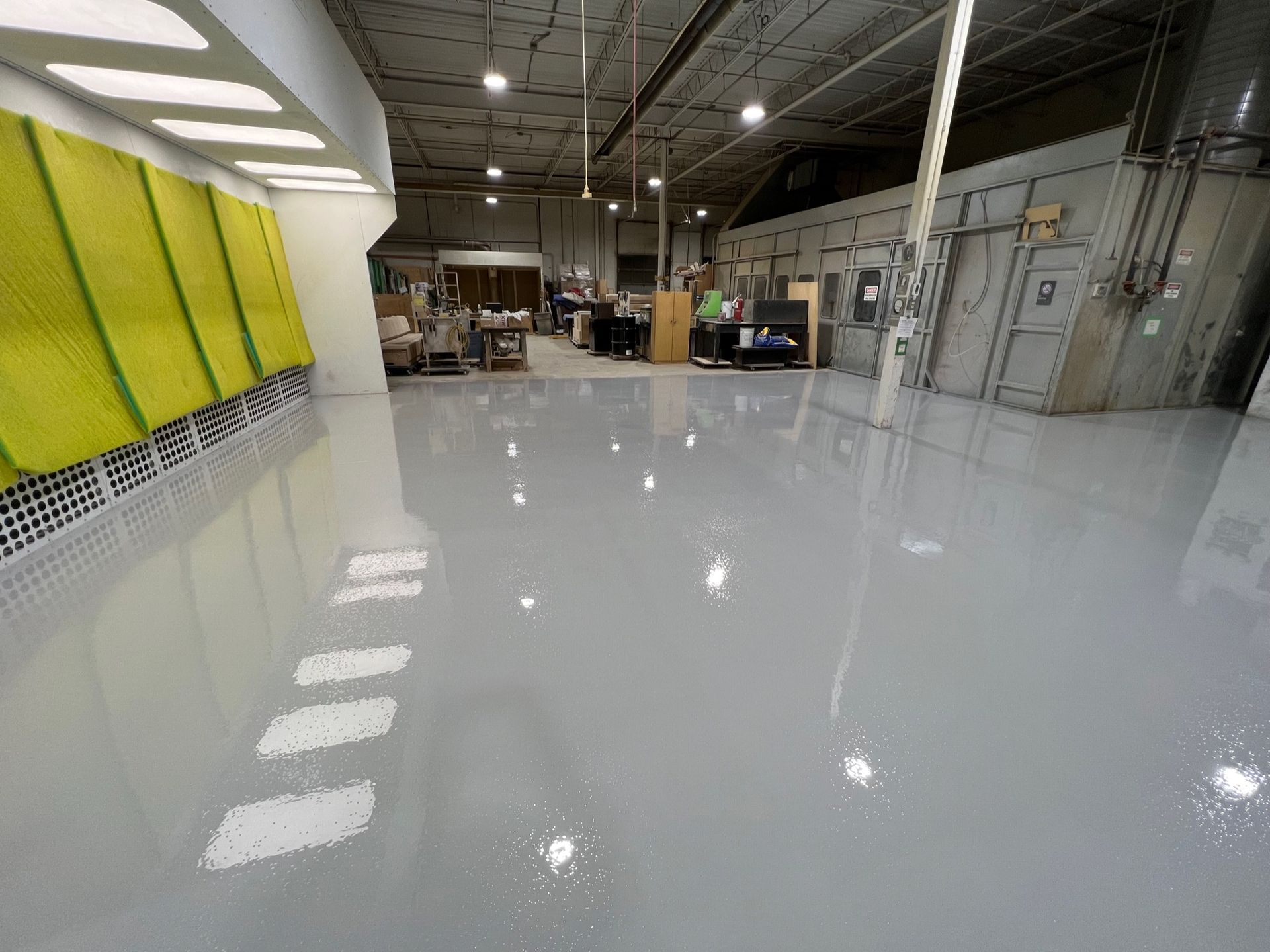 A large warehouse with a shiny floor and a yellow wall.