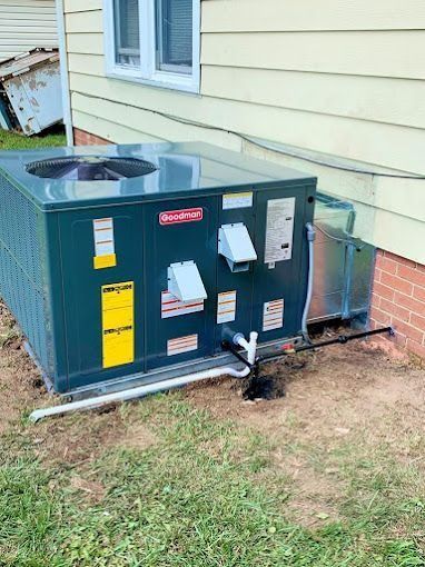 An air conditioner is sitting on the side of a house.