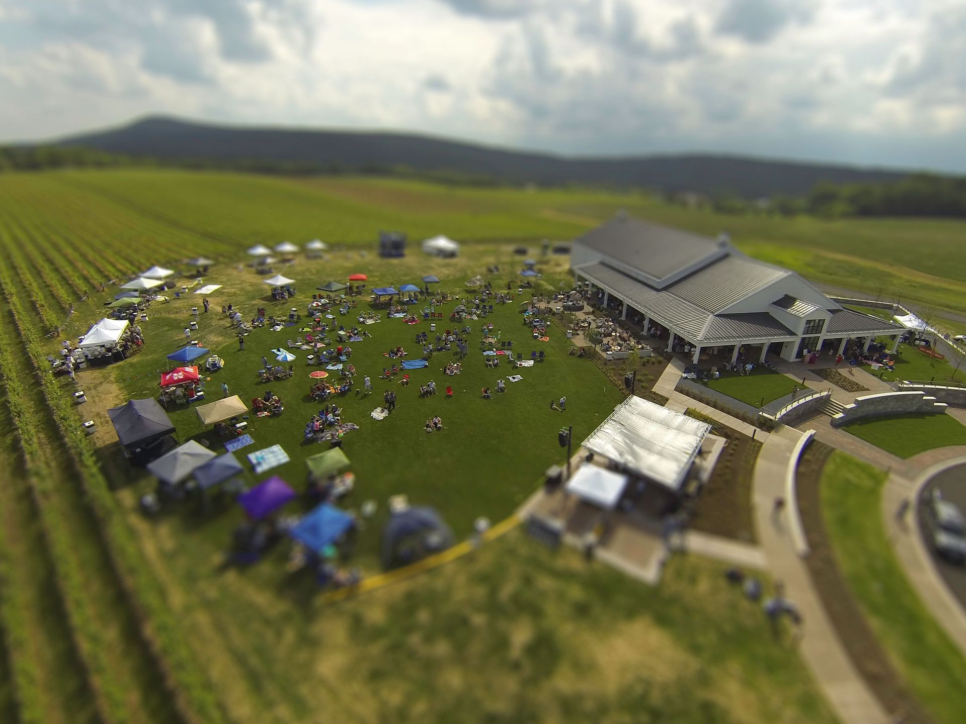 An aerial view of a large field with a large building in the background.