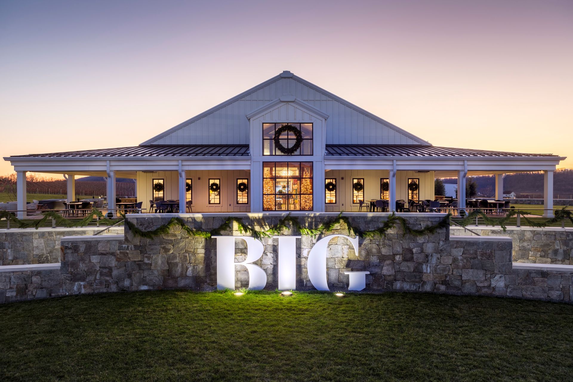 A large white barn with a sign that says big in front of it.