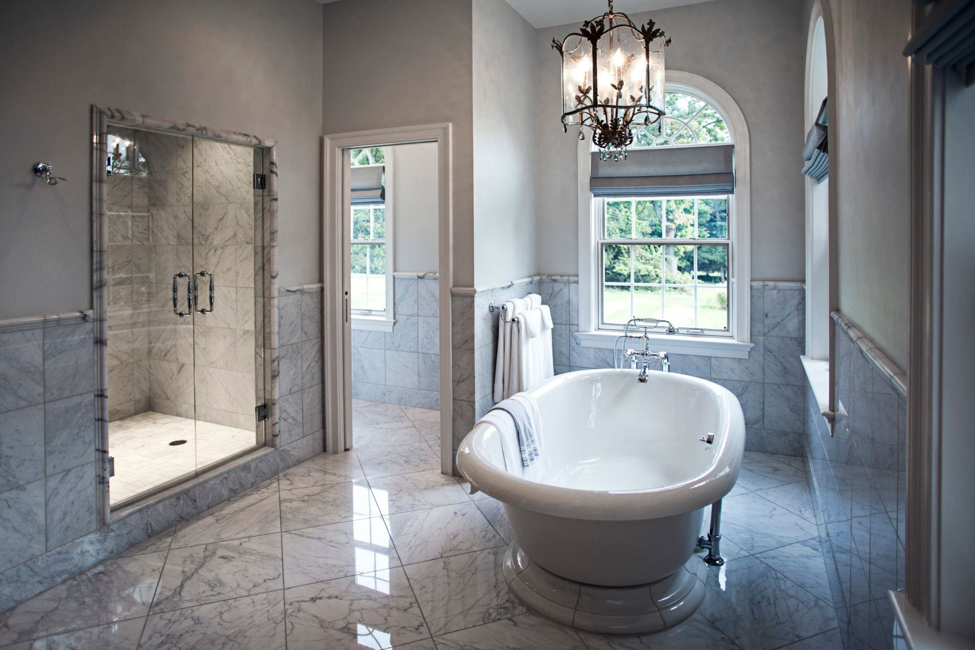 A bathroom with a tub , shower and window