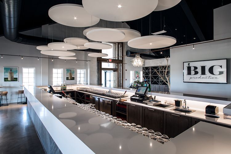 A restaurant with a long bar and a sign that says big productions.