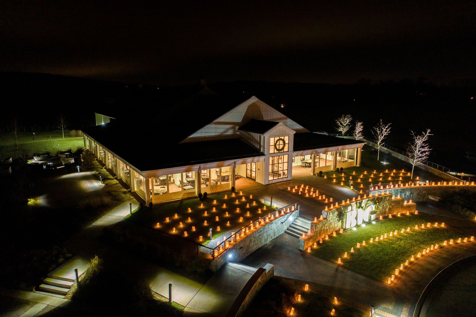 An aerial view of a large building decorated with candles at night.