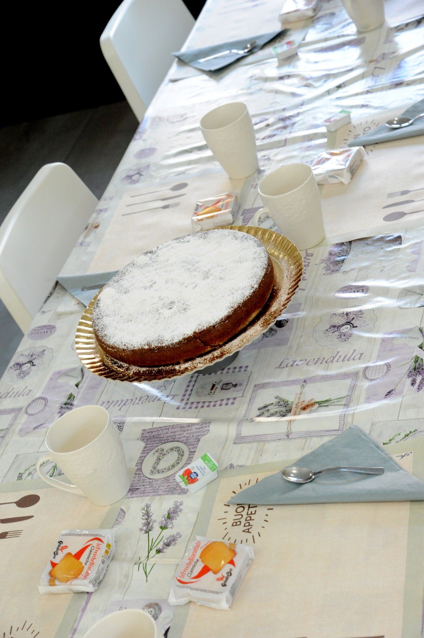 Tavolo apparecchiato con torta, bicchieri e tovaglioli