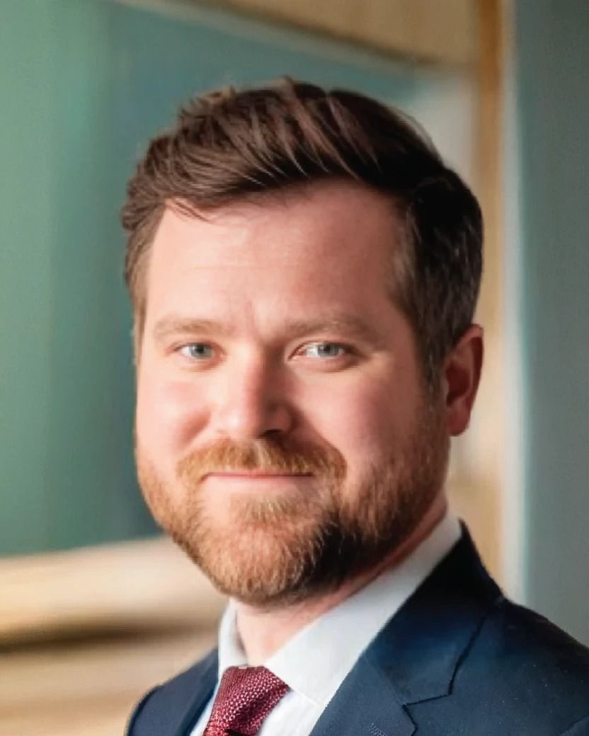 A man with a beard is wearing a suit and tie.