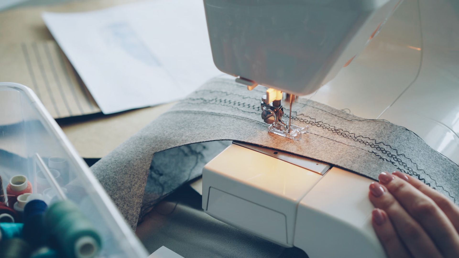 Fabric being guided through a sewing machine by hand