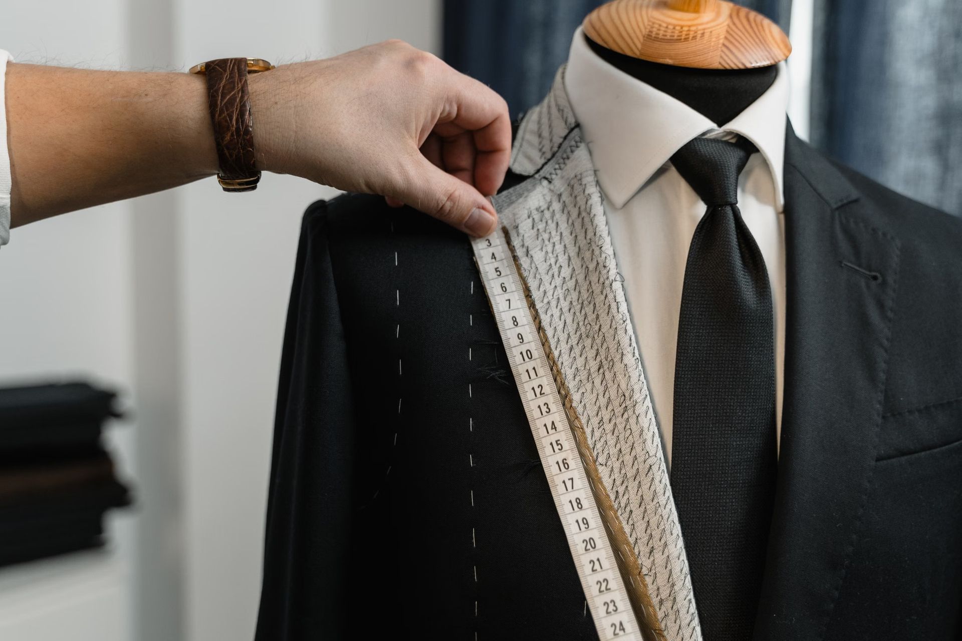 A tape measure over the lapel of a jacket being fitted