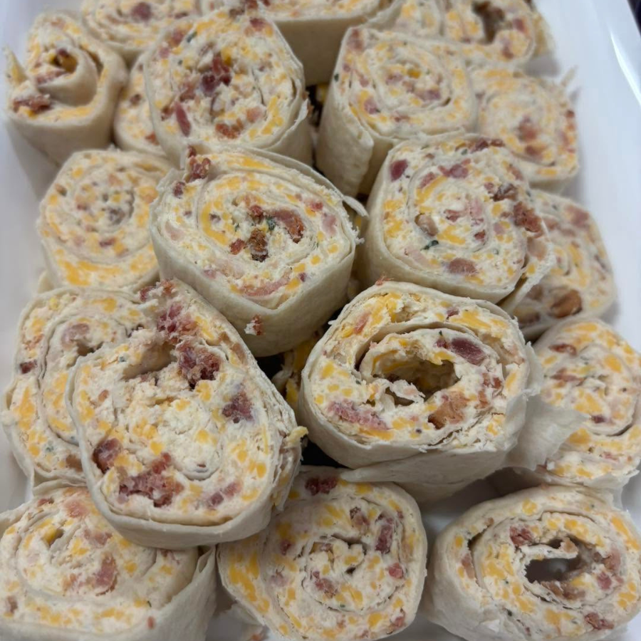 Platter of sliced tortilla pinwheels with creamy filling and bits of bacon or ham