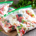 Plastic bags of chopped mixed vegetables with green zipper seals on a table